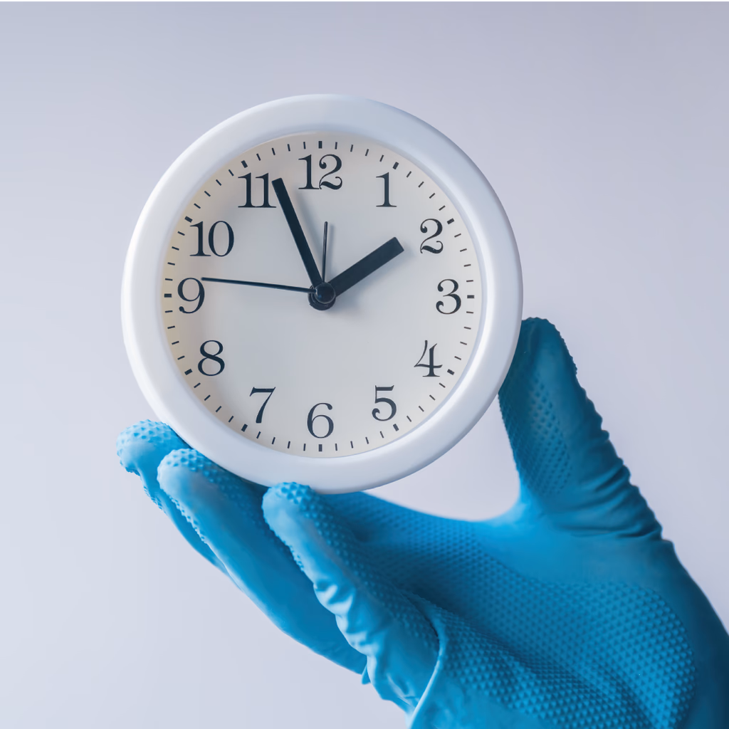 hand wearing a blue glove holding a white clock