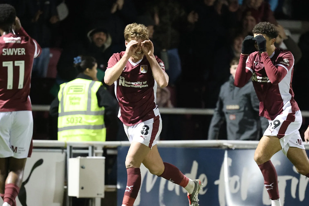 NTFC player running on pitch smiling at crowd